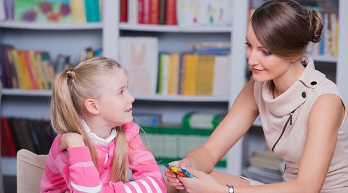 53061557 - child psychologist with a little girl, a child draws with colored pencils